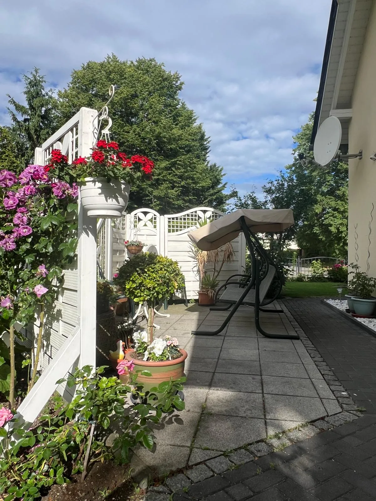Gartenteil mit Schaukelbank und Raucherinsel